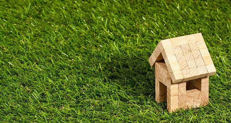 small house made of jenga blocks sitting on grass