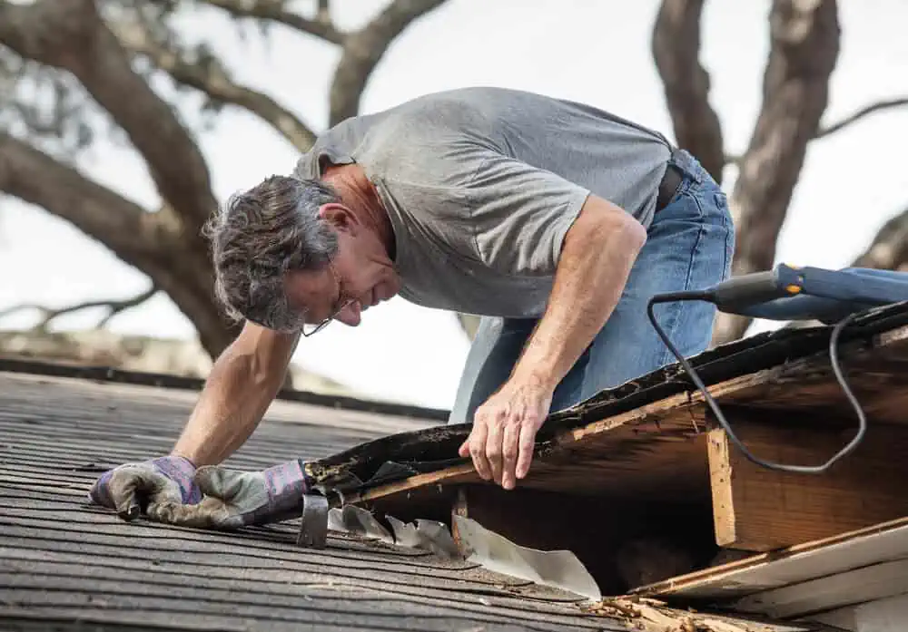 man checking roof considering a home repair emergency loan